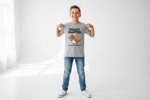 Pojke med grå T-shirt som visar "Toast Master" med en kockdinosaurie.